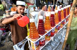 A roadside vendor sells cold beverages to customers amid hot weather in the provincial capital.