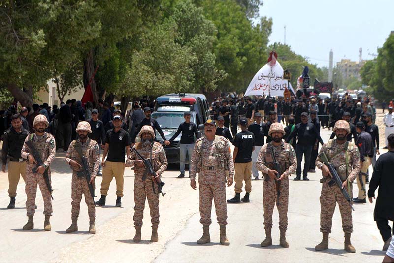 Security officials standing high alert in front of mourners attending a procession on 9th of Murramul Harram at Latifabad. Muharramul Haram is known as the first month of the Islamic calendar and the mourning month in remembrance of the martyrdom (Shahadat) of Hazrat Imam Hussain (RA), the grandson of the Holy Prophet Mohammad (PBUH)