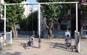 Children enjoy swings at a neighborhood park, as they make the most of their summer holidays, finding simple outdoor fun despite the scorching heat gripping the capital
