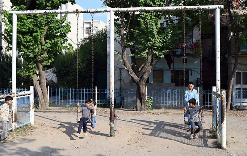 Children enjoy swings at a neighborhood park, as they make the most of their summer holidays, finding simple outdoor fun despite the scorching heat gripping the capital