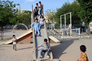 Children enjoy swings at a neighborhood park, as they make the most of their summer holidays, finding simple outdoor fun despite the scorching heat gripping the capital