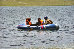 Tourists enjoy boating in Shandur Lake, a breathtaking alpine glacial lake at 3,700 meters on the Shandur Plateau, located between Chitral and Ghizer