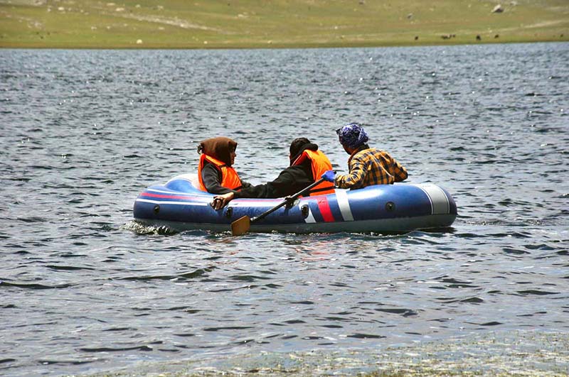 Tourists enjoy boating in Shandur Lake, a breathtaking alpine glacial lake at 3,700 meters on the Shandur Plateau, located between Chitral and Ghizer