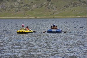 Tourists enjoy boating in Shandur Lake, a breathtaking alpine glacial lake at 3,700 meters on the Shandur Plateau, located between Chitral and Ghizer