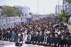 Mourners offering Zuhr prayers on M.A. Jinnah Road during the 9th Muharram-ul-Haram procession