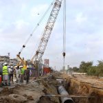 Engineers and workers are actively engaged in development work on the Red Line BRT project, with heavy machinery in operation along University Road in the provincial capital