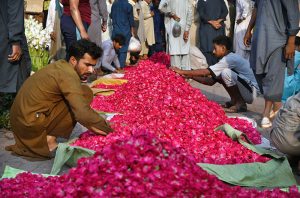 Wholesale vendors display and sell fresh rose flowers and flower petals at the wholesale flower market in the city.