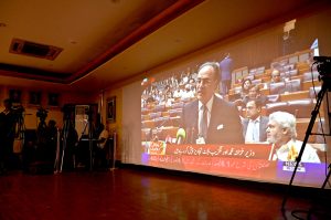 Members of the business community listen to the Federal Budget 2026–27 speech by Finance Minister Muhammad Aurangzeb, broadcast live on a multimedia screen at the Karachi Chamber of Commerce & Industry (KCCI) Auditorium