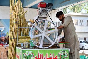 A vendor is busy making sugarcane juice at Sheikh Zayed Children Hospital Road
