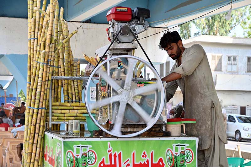 A vendor is busy making sugarcane juice at Sheikh Zayed Children Hospital Road