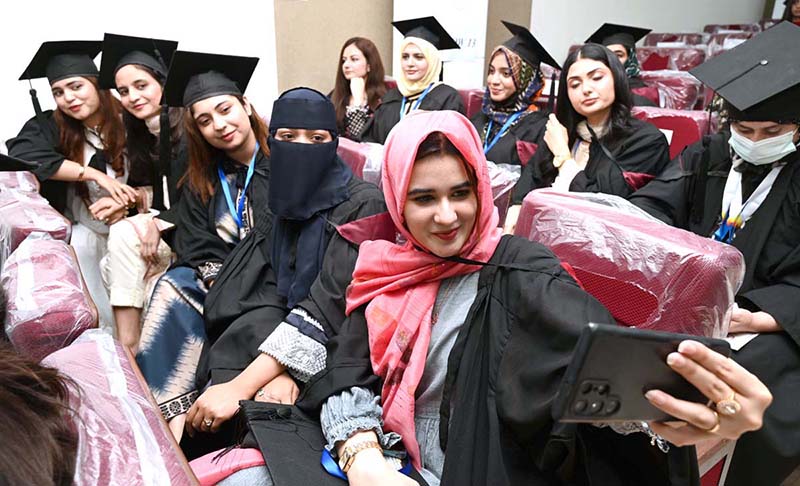 Newly graduated doctors take selfies during the second convocation of Sargodha Medical College