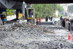 Engineers and workers are actively engaged in development work on the Red Line BRT project, with heavy machinery in operation along University Road in the provincial capital