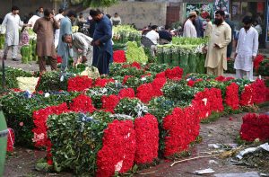 Wholesale vendors display and sell fresh rose flowers and flower petals at the wholesale flower market in the city.