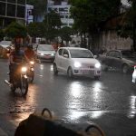 Commuters passing through rain water as the city experienced light rain and wind storm