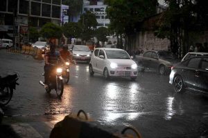 Commuters passing through rain water as the city experienced light rain and wind storm