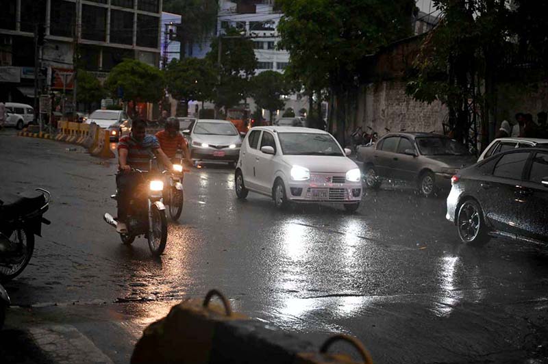 Commuters passing through rain water as the city experienced light rain and wind storm