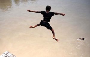 A youngster jumping in Rice Canal to get some relief from scorching hot weather in the city