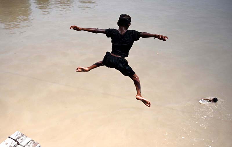 A youngster jumping in Rice Canal to get some relief from scorching hot weather in the city