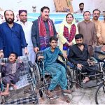 Chairman District Council Larkana Aijaz Ahmed Laghari distributing wheelchairs to disabled persons during a ceremony at the WAPDA Labor Hall