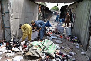 Vendors gather their salvaged goods amid the aftermath of a devastating fire that swept through the weekly H-9 Bazaar near Peshawar Mor in the Federal Capital, leaving numerous shops damaged and traders counting their losses.