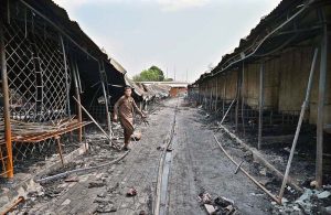 Vendors gather their salvaged goods amid the aftermath of a devastating fire that swept through the weekly H-9 Bazaar near Peshawar Mor in the Federal Capital, leaving numerous shops damaged and traders counting their losses.