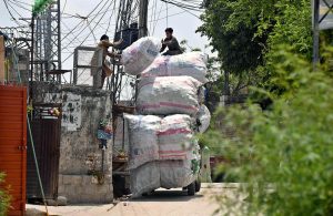 Gypsy persons are busy loading bags full of plastic bottles onto a delivery vehicle in Tarlai after collecting them from different points.