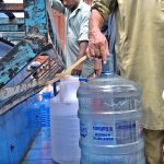 People filling their pots with clean drinking water from filtration plant at Dhoke Kala Khan