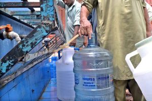 People filling their pots with clean drinking water from filtration plant at Dhoke Kala Khan