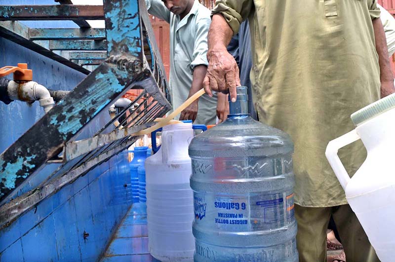 People filling their pots with clean drinking water from filtration plant at Dhoke Kala Khan