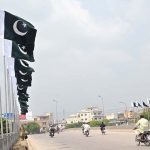 A view of national flags are displayed on bridge at Islamabad Expressway in connection with the upcoming Independence Day celebrations