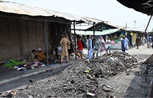 Vendors display footwear for sale amid the burnt ruins of H-9 weekly Bazaar, showing remarkable resilience as they resume trade following the devastating fire that gutted the market