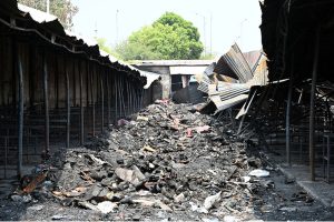 Vendors display footwear for sale amid the burnt ruins of H-9 weekly Bazaar, showing remarkable resilience as they resume trade following the devastating fire that gutted the market
