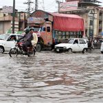 Vehicles passing through rainwater accumulated at IJP Road during rain in the Federal Capital