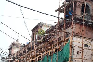 Workers are busy carrying out construction and restoration work on an old building in Anarkali Bazaar
