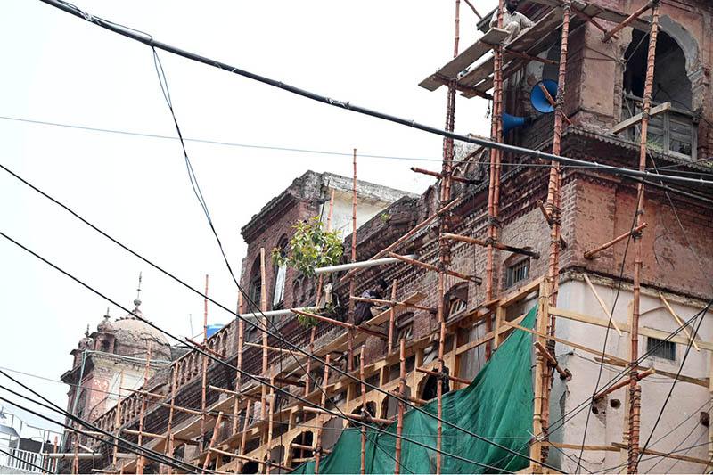 Workers are busy carrying out construction and restoration work on an old building in Anarkali Bazaar