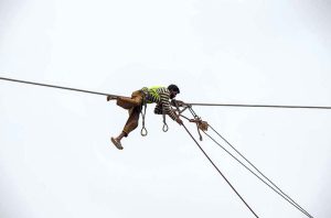 WAPDA staffer busy install new electricity cables along Lethrar Road.