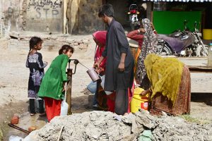 Villagers fill their pots with clean drinking water from a hand pump near Hala Naka.