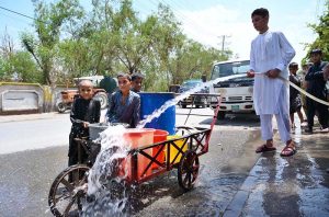 Gypsy children filling drinking water from the roadside tube well near Haji Camp Ada.