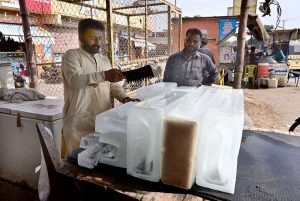 A vendor selling ice to the customer as demand increased during hot weather in the city.