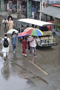A youngster on the way carrying umbrella during rain that experienced the city.