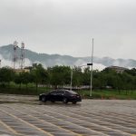 Low-lying clouds and mist blanket the Margalla Hills as a vehicle navigates through a rain-soaked road in Federal Capital following heavy monsoon rainfall
