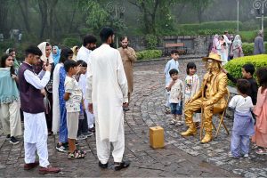 A young vendor is making bubbles with a bubble-making toy to attract children and sell the toy at the famous picnic point, Daman-e-Koh