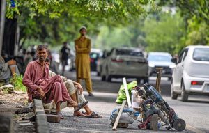 Labourers along with their tools are seen sitting on the roadside, waiting for clients to hire them for work in the Federal Capital.