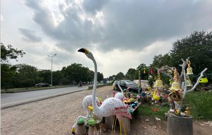 Decorative lawn ornaments and handcraft items are showcased for sale along Park Road.