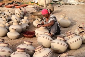 A woman worker paints the clay-made pots at her work place Kumharpara.