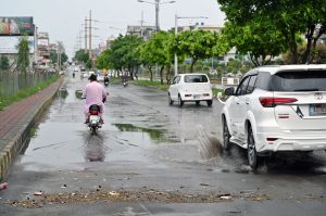 Vehicle passing through rain water accumulated on the road after rain in the city.