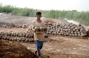 A woman worker paints the clay-made pots at her work place Kumharpara.