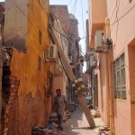 A dangerously leaning concrete electricity pole, supported only by a nearby house wall and a web of overhead power cables, carries multiple electricity meters and live wires, posing a serious threat to residents in the narrow street of Mohalla Qasab Pura near Khooni Burj. The pole has remained in a hazardous condition for nearly 10 days as pedestrians continue to pass beneath it and locals urge authorities to carry out immediate repairs