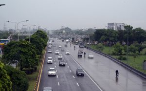 Low-lying clouds and mist blanket the Margalla Hills as a vehicle navigates through a rain-soaked road in Federal Capital following heavy monsoon rainfall