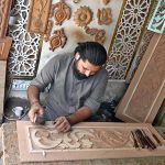A worker is busy in carving different designs on sheet in his workshop at Saidpur Road